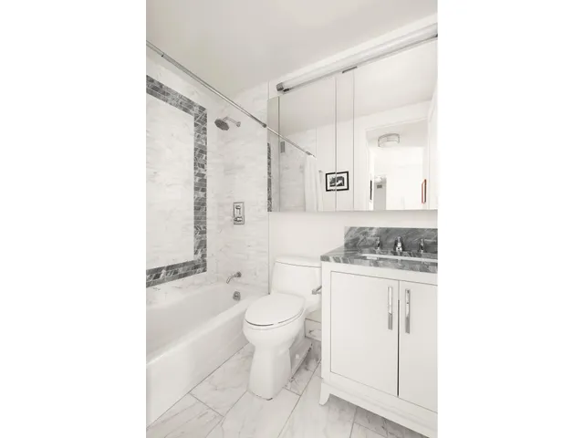 a bathroom with a granite countertop sink a toilet and a bathtub