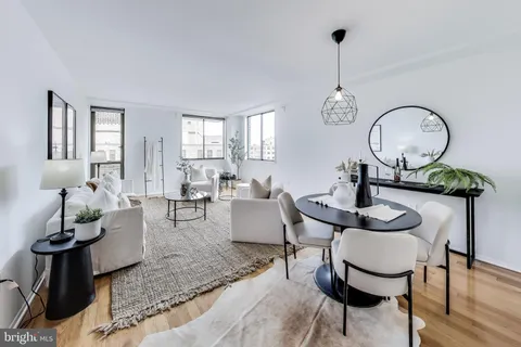 a living room with furniture a rug and a window