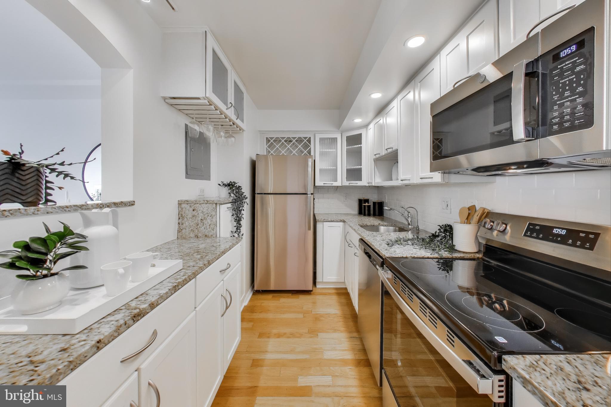 1325 18th Street Northwest, Unit 1009 Washington, DC 20036 - Photo 5 of 24 a kitchen with stainless steel appliances granite countertop a sink and a stove