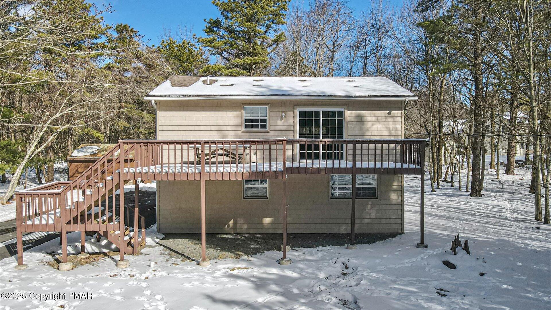 277 Fern Ridge Road Blakeslee, PA 18610 - Photo 28 of 46 a view of a house with a wooden deck and a barbeque