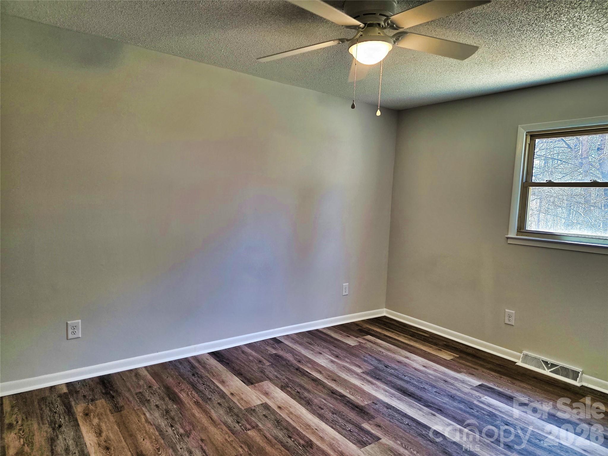 323 Mt Bethel Road Harmony, NC 28634 - Photo 14 of 25 an empty room with a window and ceiling fan