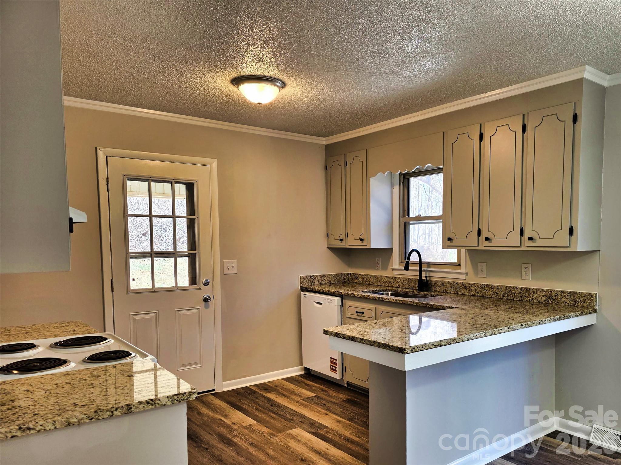 323 Mt Bethel Road Harmony, NC 28634 - Photo 8 of 25 a kitchen with granite countertop a sink a stove and cabinets