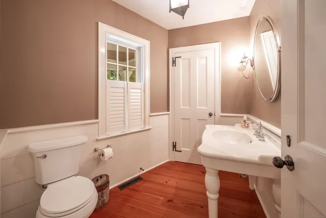 a bathroom with a sink a toilet and mirror