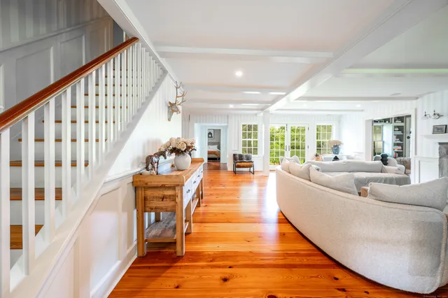 a dining room with wooden floor and large windows