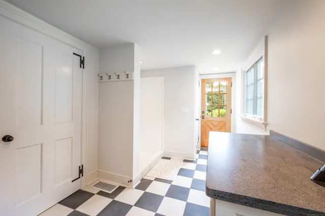 a view of a hallway with wooden floor and a bathroom