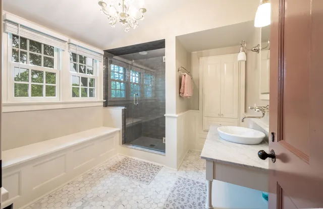 a bathroom with a tub sink and mirror