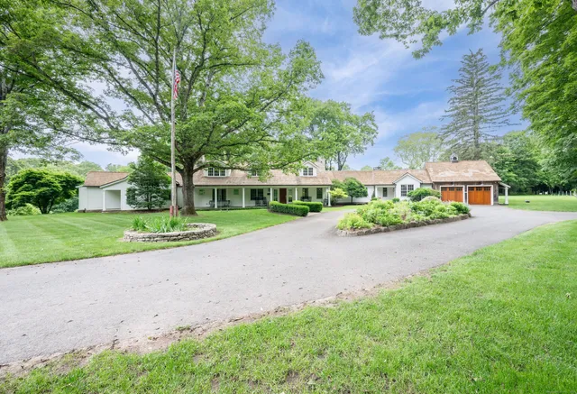 a view of road with house and trees in the background