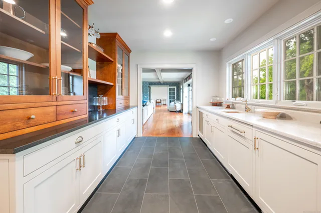 a large white kitchen with a large window