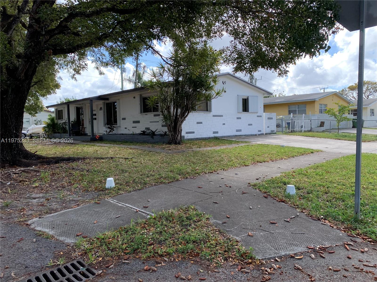 401 Southwest 8th Street, Unit A Hallandale Beach, FL 33009 - Photo 16 of 17 a front view of a house with a garden and trees