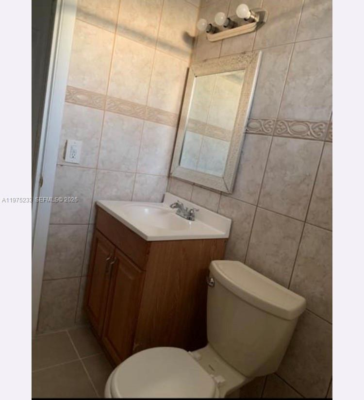 401 Southwest 8th Street, Unit A Hallandale Beach, FL 33009 - Photo 10 of 17 a bathroom with a sink a toilet a mirror and shower