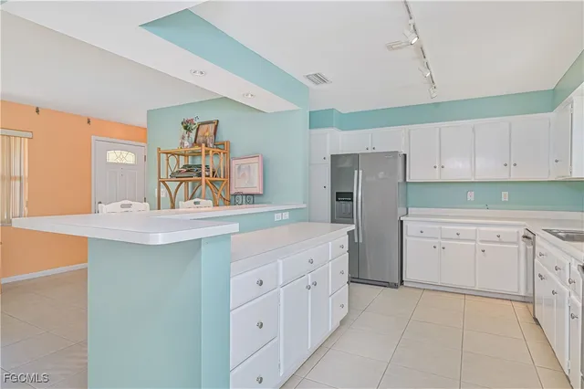 a kitchen with white cabinets and sink