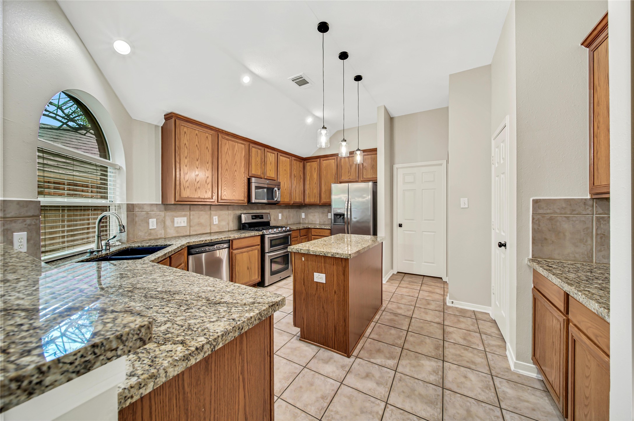 14526 Red Tailed Hawk Lane Houston, TX 77044 - Photo 10 of 40 a kitchen with stainless steel appliances granite countertop a sink stove and refrigerator
