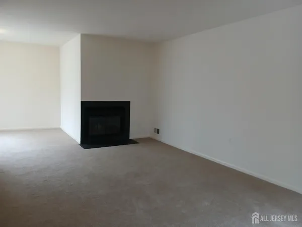 a view of an empty room with a fireplace