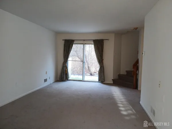 an empty room with a fireplace and windows
