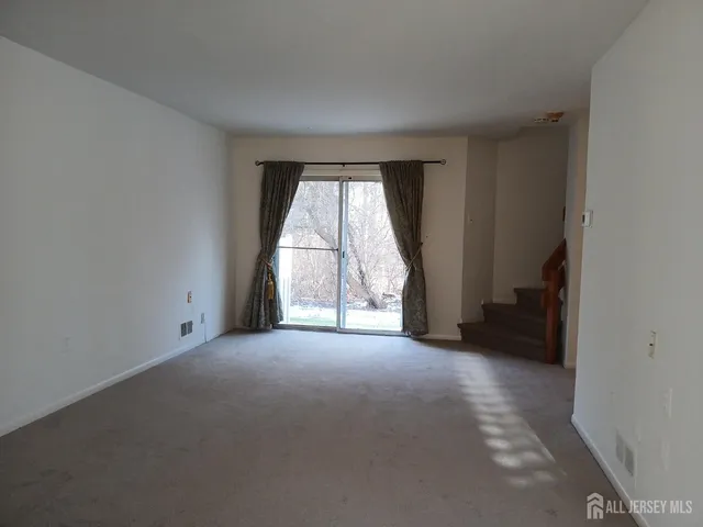 an empty room with a fireplace and windows