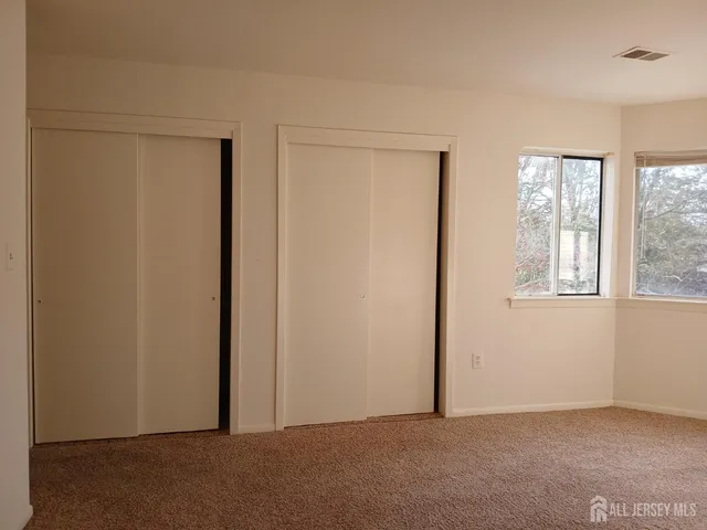 an empty room with windows and closet