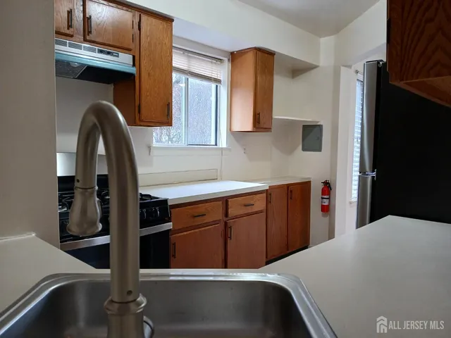 a kitchen with stainless steel appliances kitchen island a refrigerator a sink and cabinets