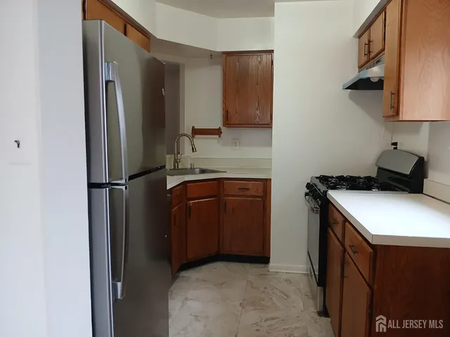a kitchen with stainless steel appliances granite countertop a refrigerator and a sink