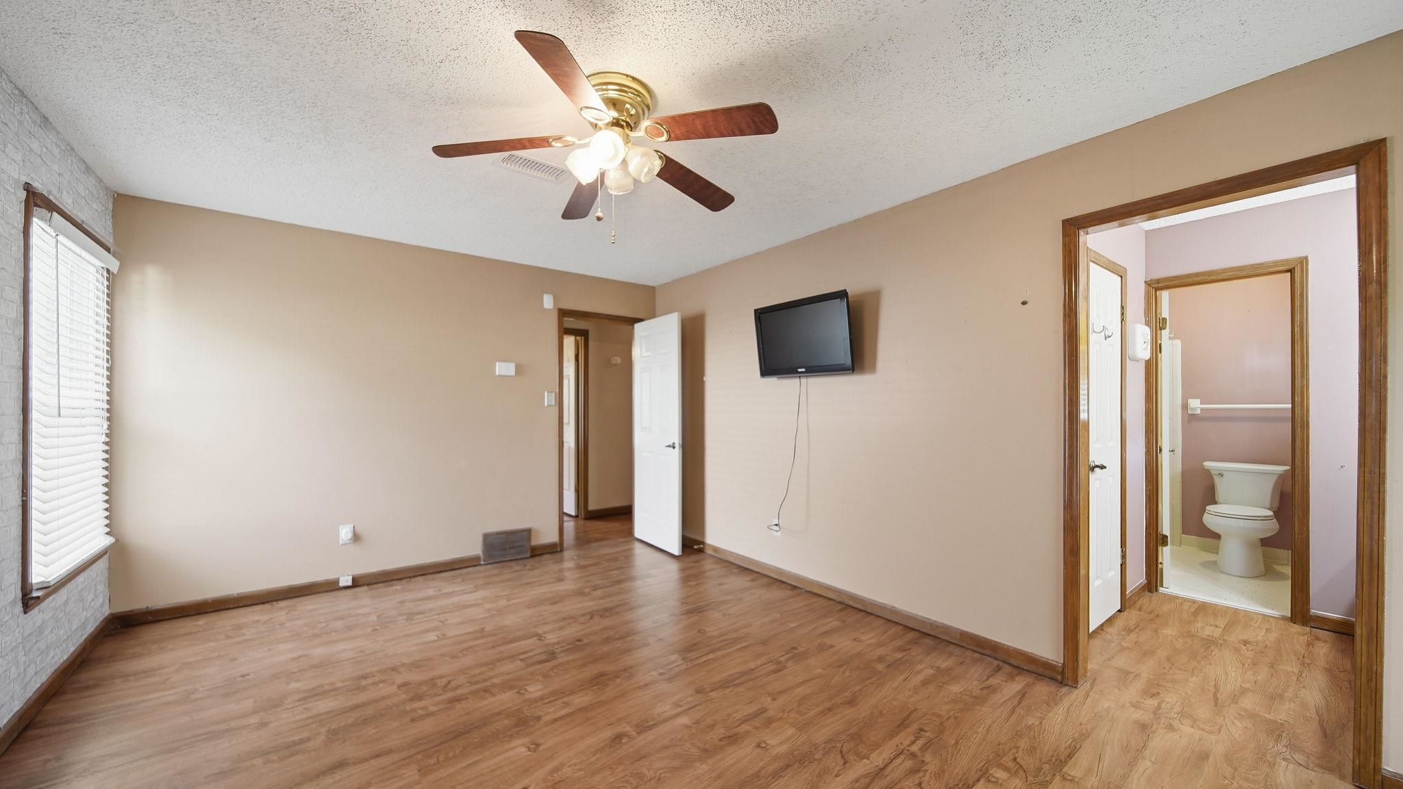 5069 Ross Road Memphis, TN 38141 - Photo 19 of 40 Unfurnished bedroom featuring a textured ceiling, light wood-style flooring, a ceiling fan, and connected bathroom