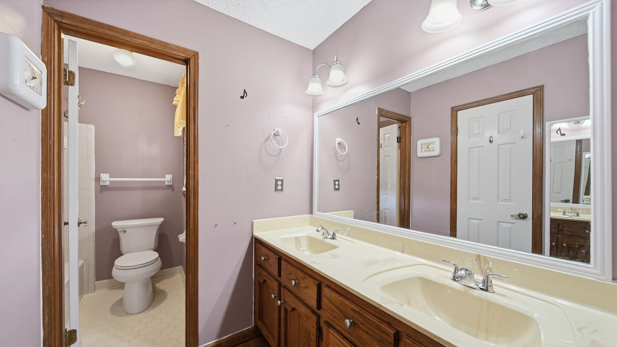 5069 Ross Road Memphis, TN 38141 - Photo 20 of 40 Bathroom with double vanity, a textured ceiling, and dark tile patterned flooring