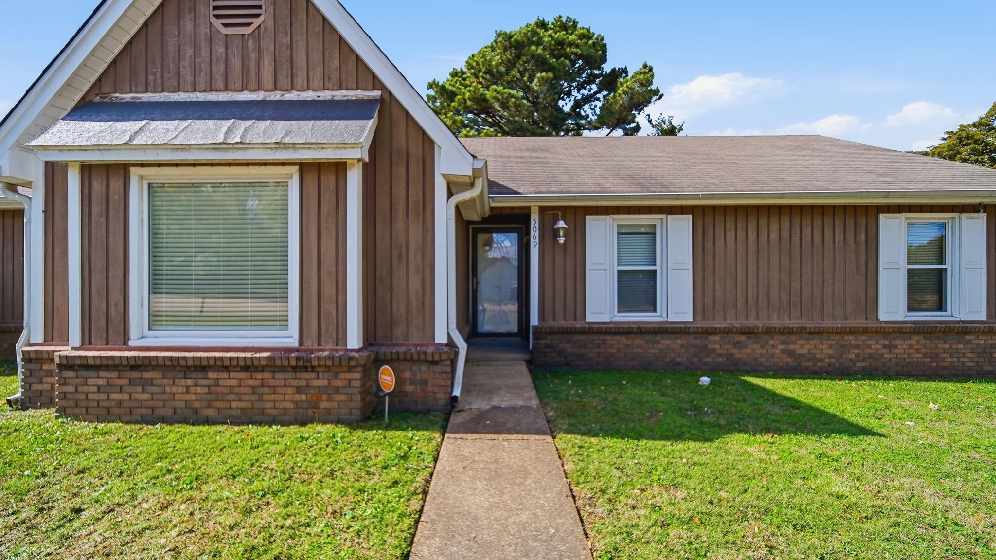5069 Ross Road Memphis, TN 38141 - Photo 2 of 40 View of front of house featuring a front yard, a shingled roof, board and batten siding, and brick siding