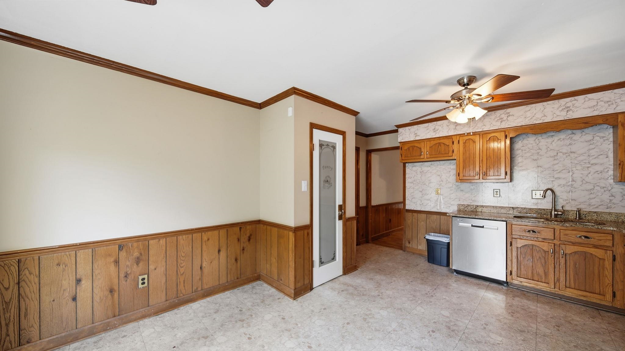 5069 Ross Road Memphis, TN 38141 - Photo 27 of 40 Kitchen with ceiling fan, a wainscoted wall, wood walls, dishwasher, and crown molding