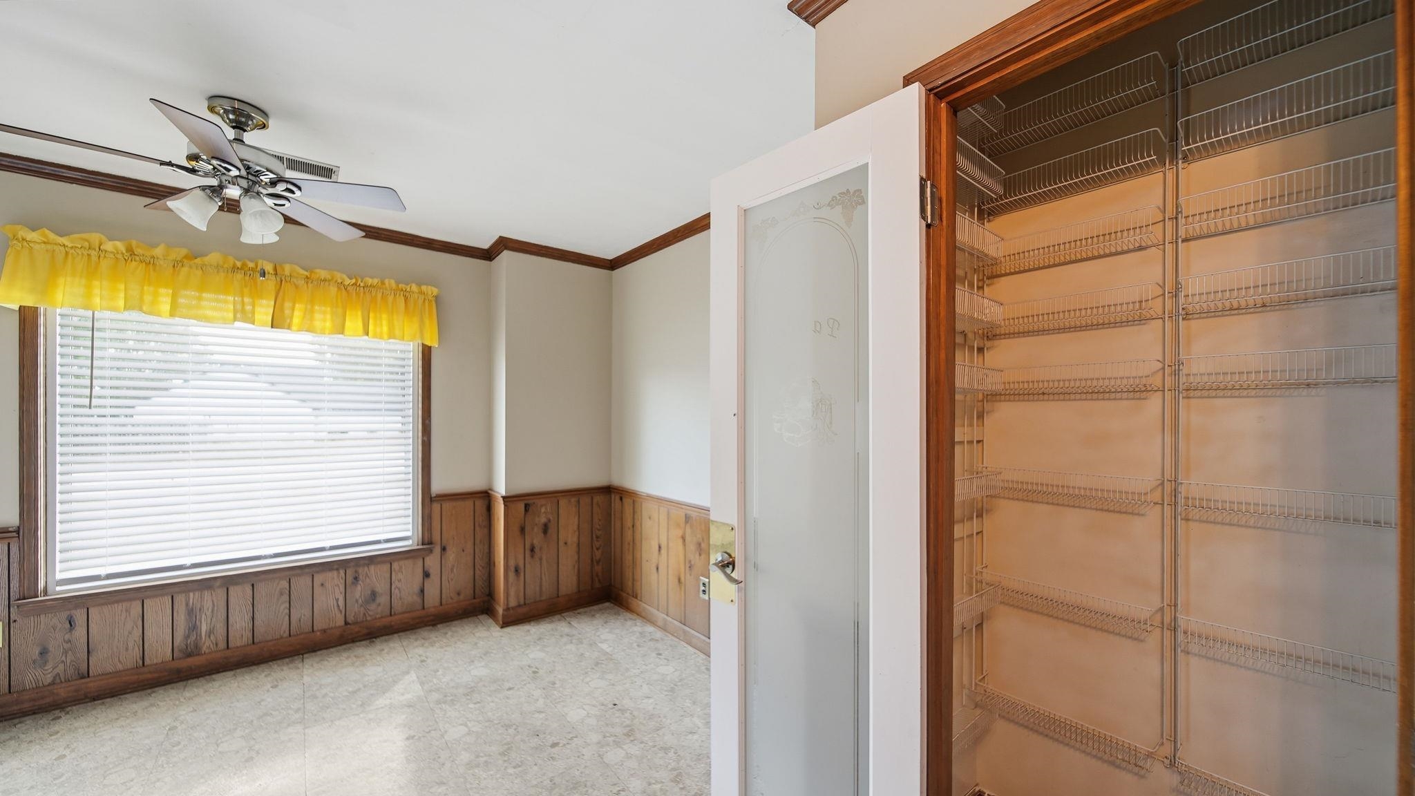 5069 Ross Road Memphis, TN 38141 - Photo 30 of 40 Empty room with crown molding, wood walls, wainscoting, light floors, and ceiling fan