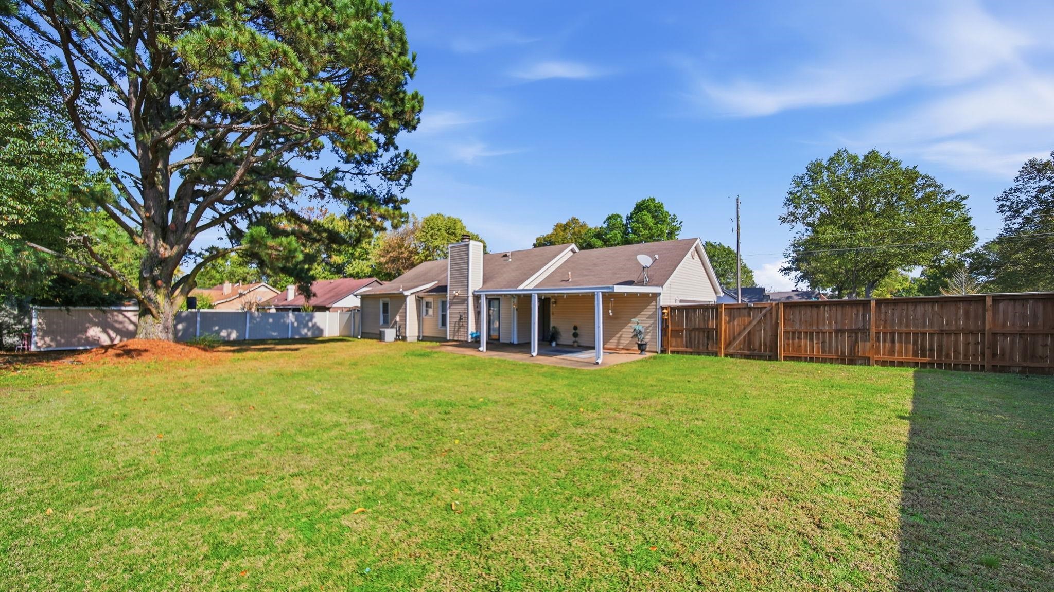 5069 Ross Road Memphis, TN 38141 - Photo 38 of 40 Back of house featuring a patio area, a fenced backyard, a gate, and a chimney