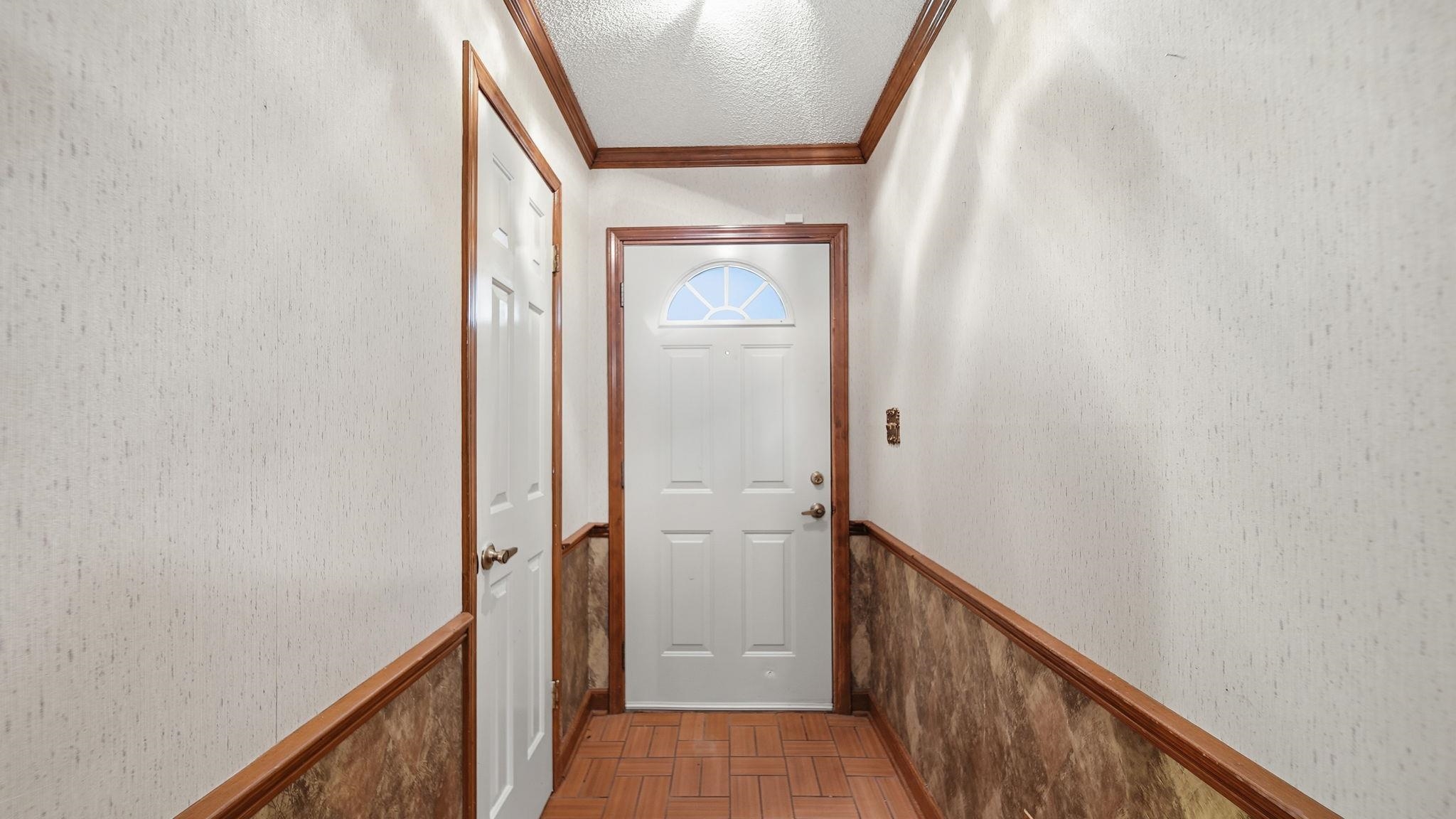 5069 Ross Road Memphis, TN 38141 - Photo 6 of 40 Entryway with crown molding, a textured ceiling, wainscoting, and wallpapered walls