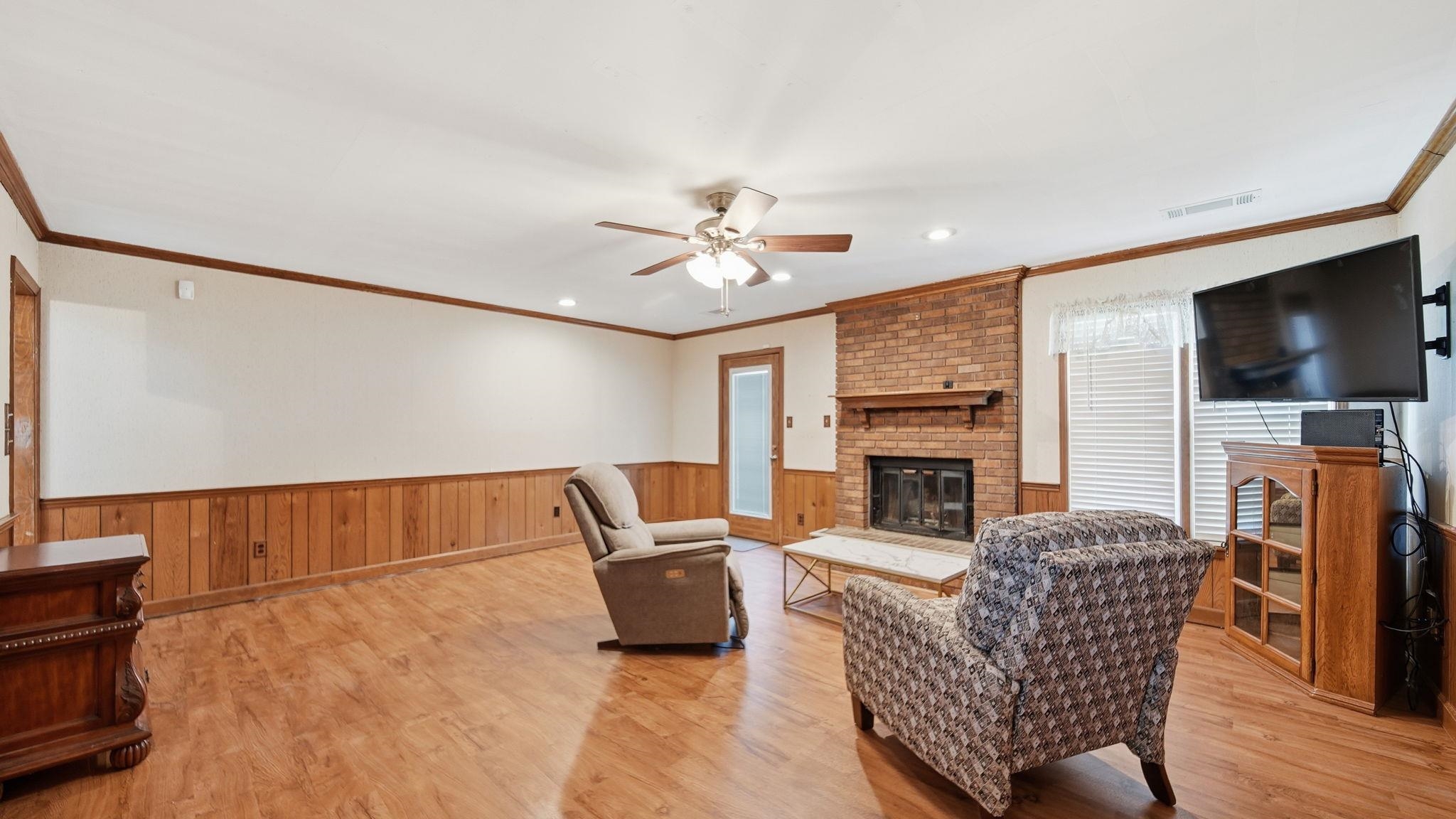 5069 Ross Road Memphis, TN 38141 - Photo 7 of 40 Living area featuring a brick fireplace, light wood-type flooring, ceiling fan, crown molding, and recessed lighting