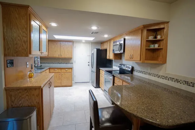 a kitchen with granite countertop sink cabinets and stainless steel appliances