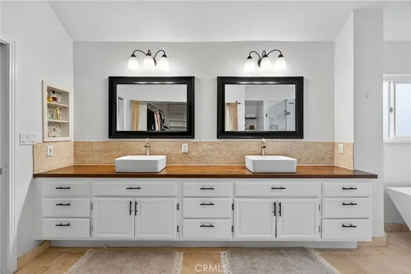 a bathroom with double vanity sinks and a mirror