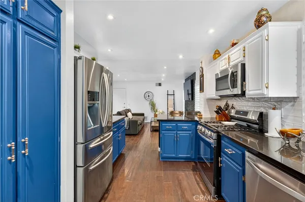a kitchen with stainless steel appliances granite countertop a refrigerator stove and sink