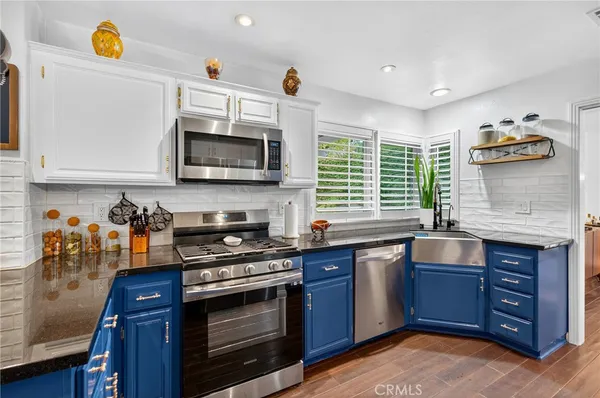 a kitchen with stainless steel appliances granite countertop a stove and a microwave