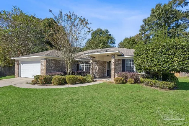 a front view of a house with a garden and trees
