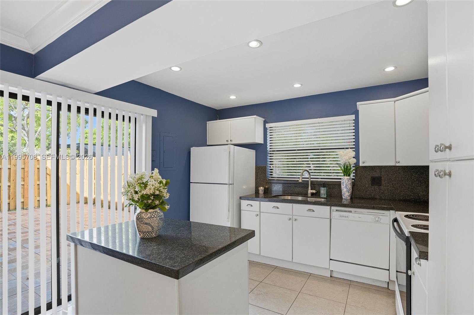 13993 Southwest 94th Cir Lane, Unit 1013 Miami, FL 33186 - Photo 13 of 36 a kitchen with stainless steel appliances granite countertop a refrigerator sink and white cabinets