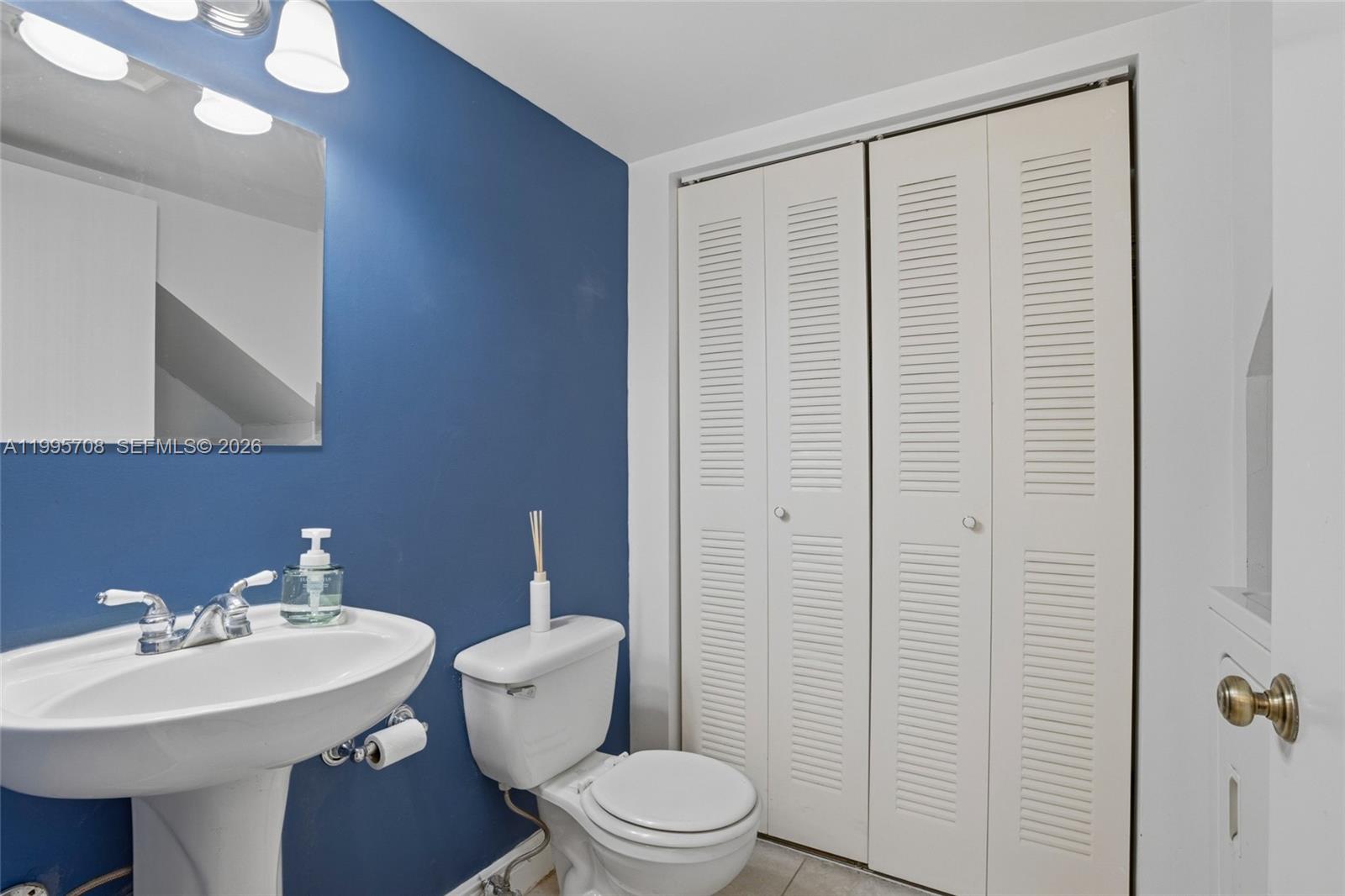 13993 Southwest 94th Cir Lane, Unit 1013 Miami, FL 33186 - Photo 17 of 36 a bathroom with a sink a toilet and shower curtain
