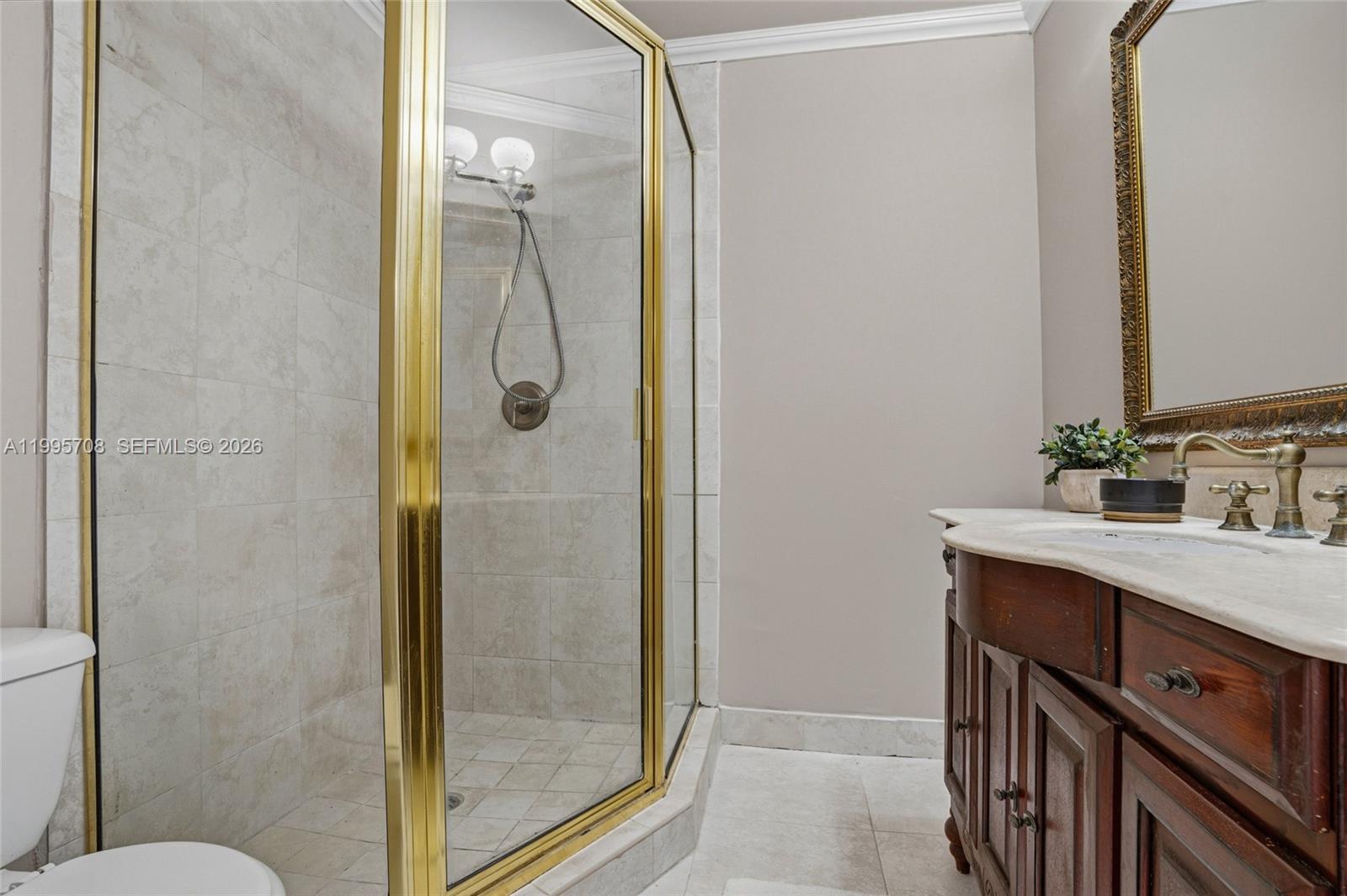 13993 Southwest 94th Cir Lane, Unit 1013 Miami, FL 33186 - Photo 22 of 36 a bathroom with a granite countertop sink a mirror and a shower