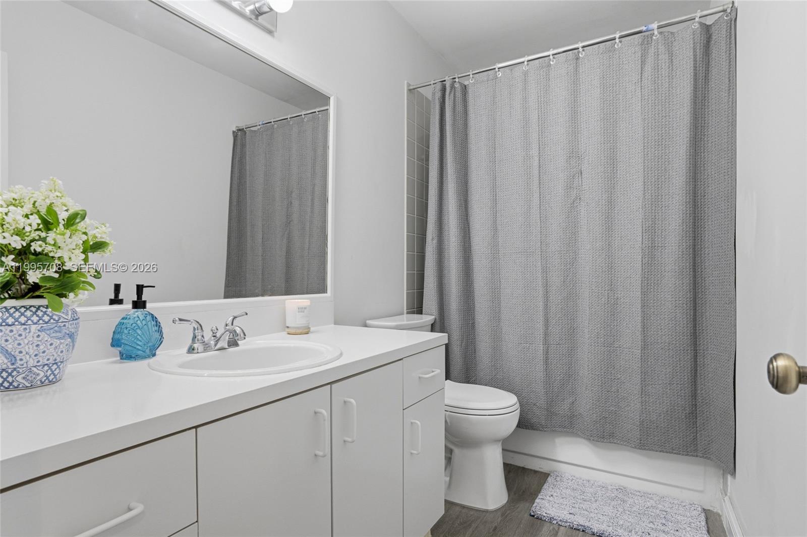 13993 Southwest 94th Cir Lane, Unit 1013 Miami, FL 33186 - Photo 24 of 36 a bathroom with a sink a toilet and shower curtain
