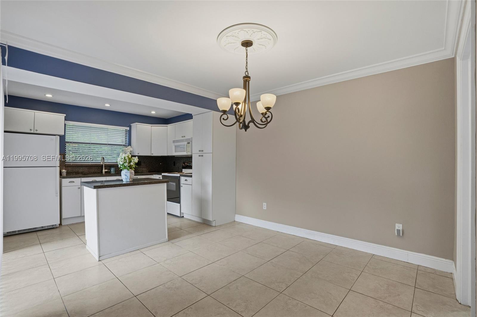 13993 Southwest 94th Cir Lane, Unit 1013 Miami, FL 33186 - Photo 10 of 36 a kitchen with a refrigerator a stove top oven and cabinets
