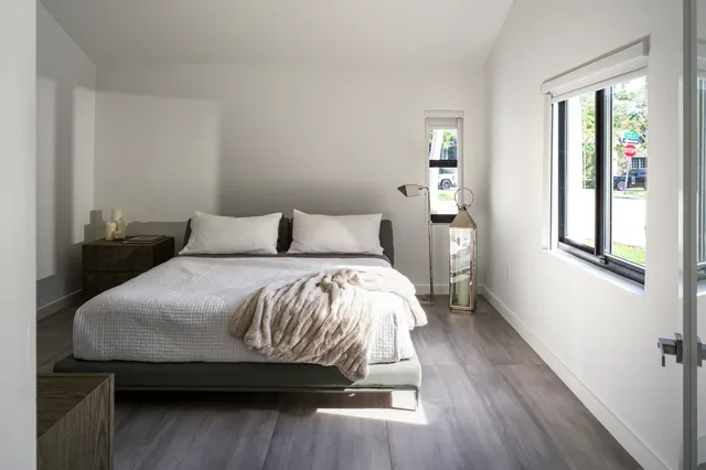 a bedroom with a bed and wooden floor