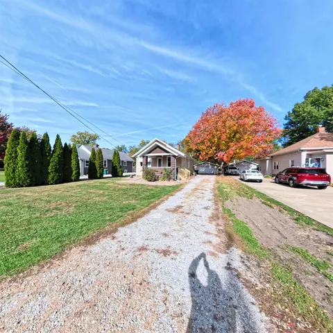 a view of a patio with table and chairs and a barbeque