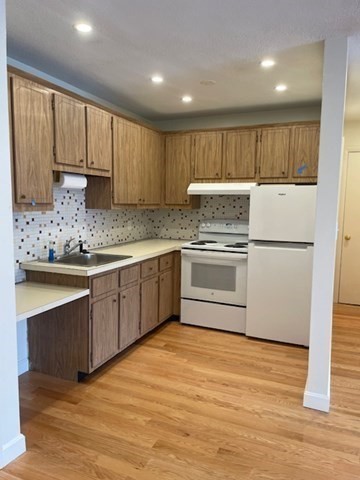 25 Custer Street, Unit 303 Boston, MA 02130 - Photo 2 of 8 a kitchen with granite countertop a sink stainless steel appliances and counter space