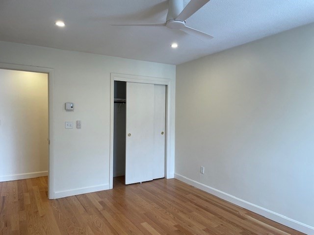 25 Custer Street, Unit 303 Boston, MA 02130 - Photo 3 of 8 an empty room with wooden floor and closet