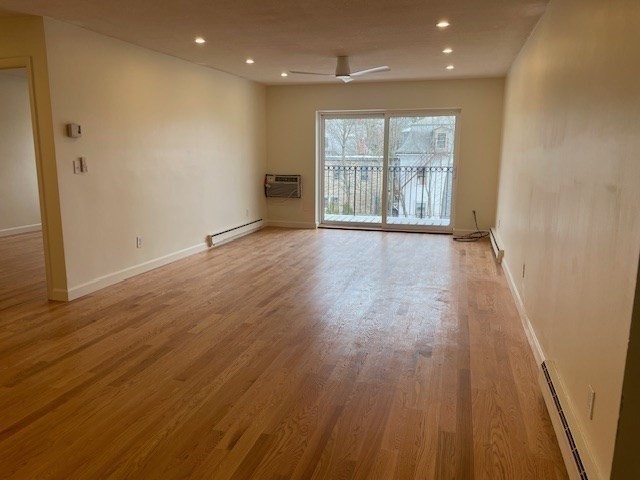 25 Custer Street, Unit 303 Boston, MA 02130 - Photo 7 of 8 an empty room with wooden floor and windows