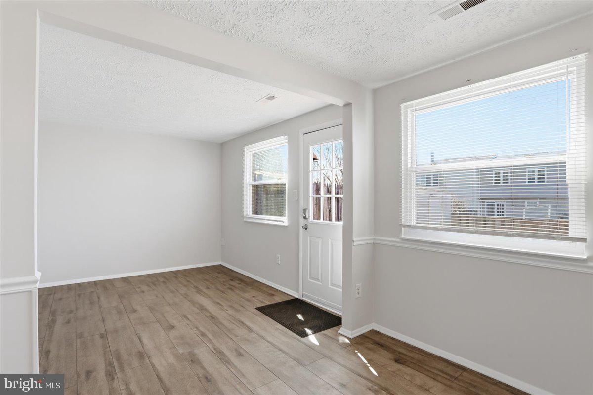 6734 Fallow Hill Court Frederick, MD 21703 - Photo 11 of 29 an empty room with wooden floor and windows
