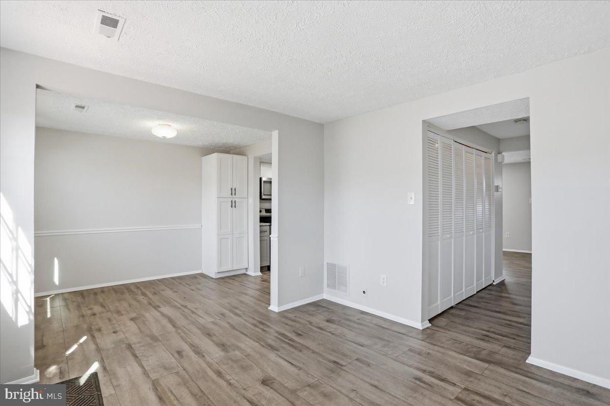 6734 Fallow Hill Court Frederick, MD 21703 - Photo 14 of 29 an empty room with wooden floor and windows