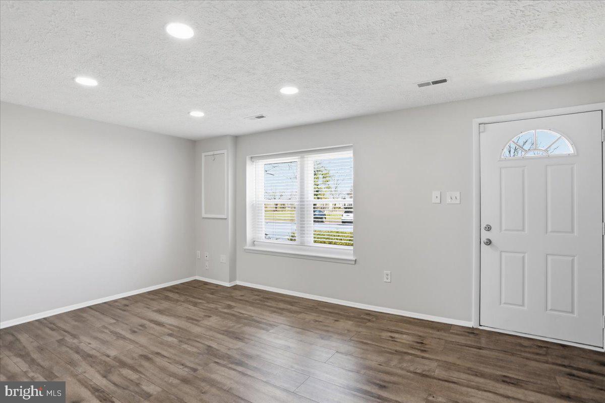6734 Fallow Hill Court Frederick, MD 21703 - Photo 5 of 29 an empty room with wooden floor and a window