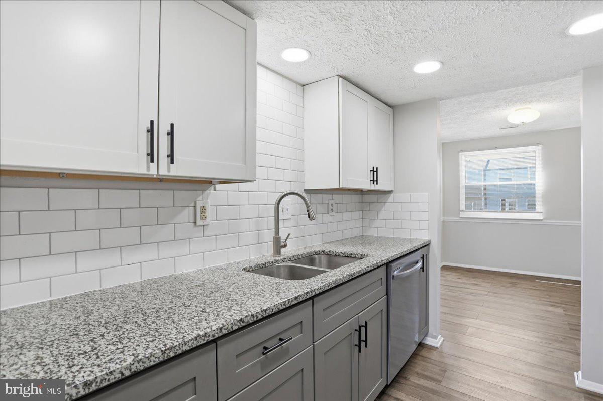 6734 Fallow Hill Court Frederick, MD 21703 - Photo 7 of 29 a kitchen with granite countertop white cabinets and sink