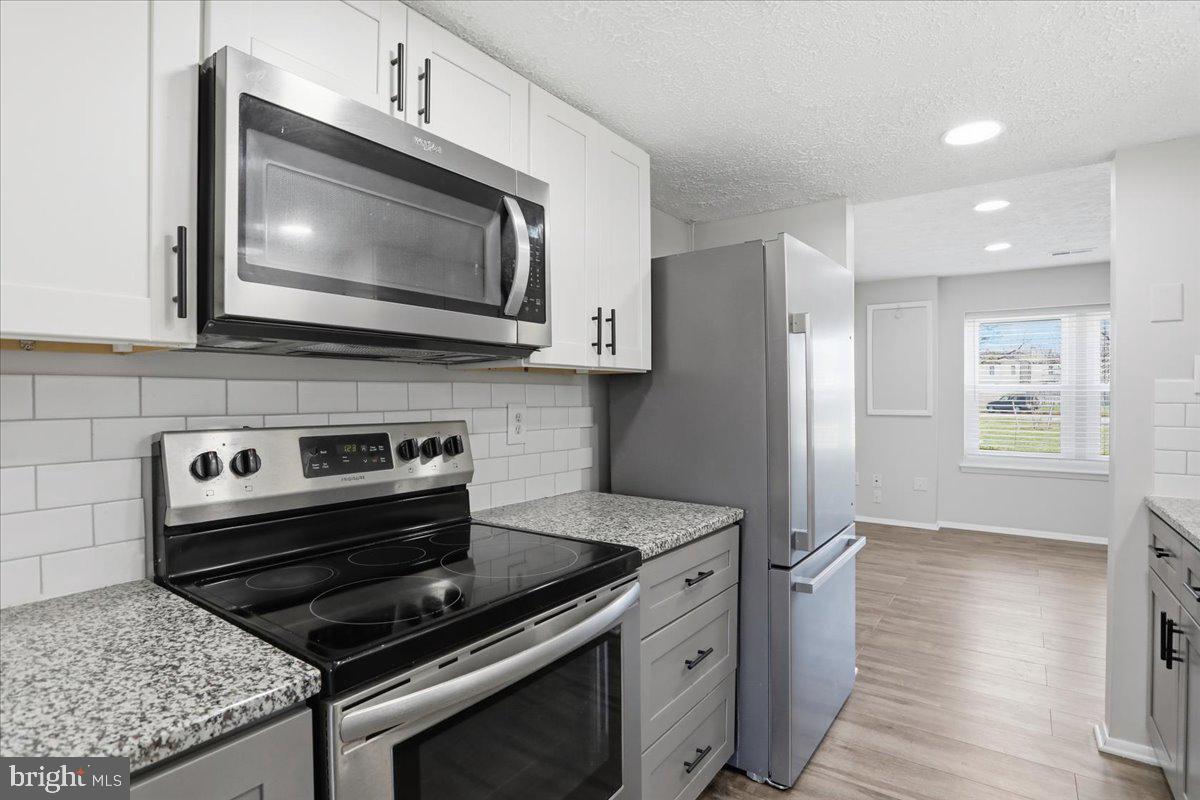 6734 Fallow Hill Court Frederick, MD 21703 - Photo 8 of 29 a kitchen with a stove and a microwave